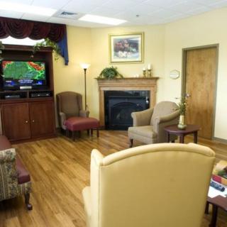 A cozy living room with comfortable chairs, a fireplace, and a television.