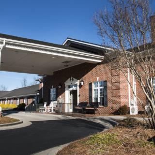 A brick building with a covered entrance and driveway.