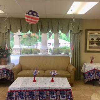 A festive indoor setting with American-themed decorations, featuring a sofa and tables adorned with patriotic decor.