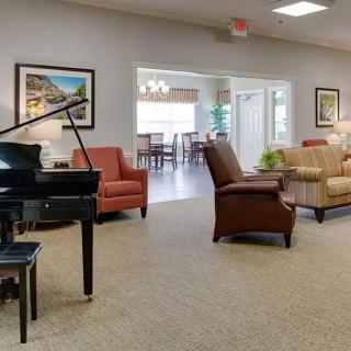 A cozy living room with a piano and comfortable seating.