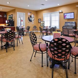An empty cafe interior with patterned chairs and round tables.