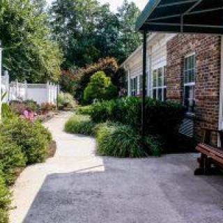 A landscaped garden with a pathway next to a brick building.