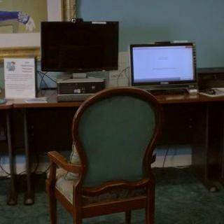A workspace featuring a computer setup with a chair and desk.