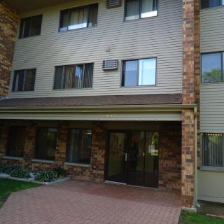 The exterior view of a residential apartment building with a brick facade and multiple windows.