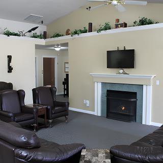 A cozy living room with leather seating, a fireplace, and a mounted television.