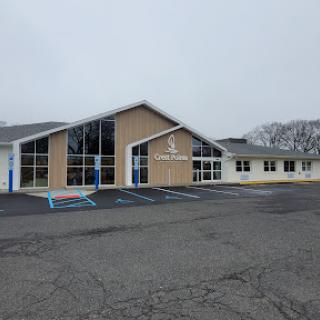 A modern community center building with large windows, set in a foggy atmosphere.