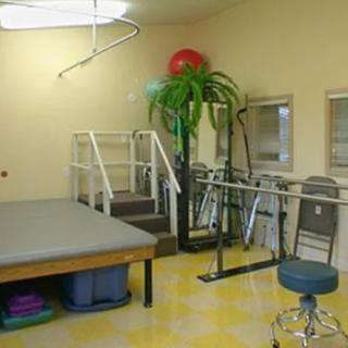 A physical therapy room equipped with exercise tools and a therapy table.