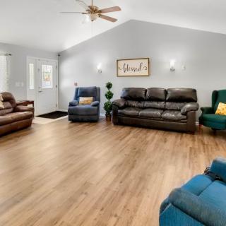 A spacious living room with modern furnishings and wooden flooring.