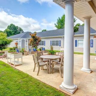 A beautiful patio with outdoor furniture and columns, set in a sunny garden.