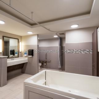 A modern and clean bathroom featuring a bathtub, vanity sink, and contemporary lighting.