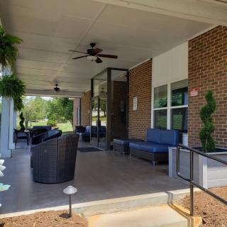 A cozy porch with comfortable outdoor seating and lush plants.