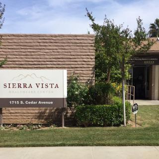 Entrance to Sierra Vista with a sign and landscaped surroundings.