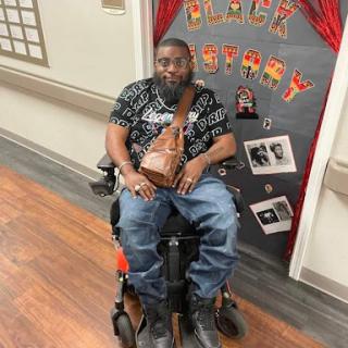 A man in a wheelchair enjoying a celebration, surrounded by festive decorations.