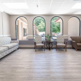 A bright and inviting lounge area featuring comfortable seating and large windows that let in natural light.