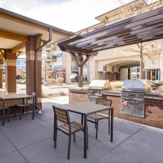 Outdoor patio area with BBQ grills and seating at an apartment complex.