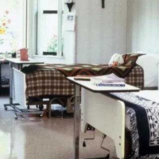 A hospital room with two beds and medical equipment.