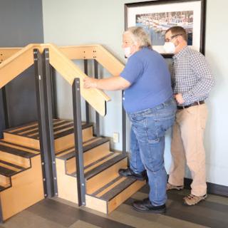A person assisting another individual up the stairs, showcasing support in mobility.