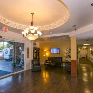 A well-lit lobby with a chandelier and seating area near the entrance.