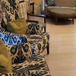 A cozy living room setting with patterned upholstered chairs and green cushions.