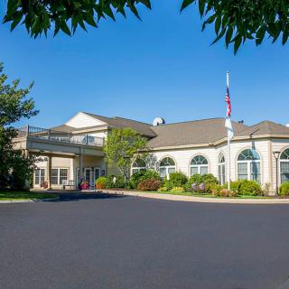 A residential building with a landscaped front and clear skies.