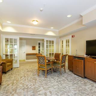 A cozy living room featuring comfortable seating, a television, and wooden cabinets, creating a welcoming ambiance.