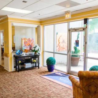 A welcoming lobby area with carpeted flooring, glass doors, and comfortable seating.