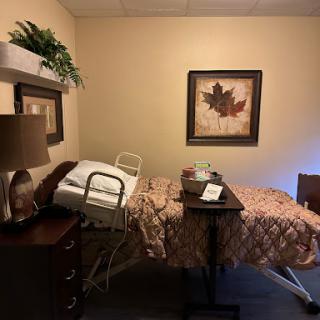 A cozy hospital room with a bed, bedside table, and decorative elements.