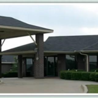 A suburban building with a covered entrance and landscaped surroundings.