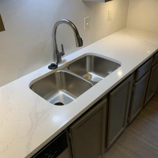 A modern kitchen with a double stainless steel sink and a sleek countertop.