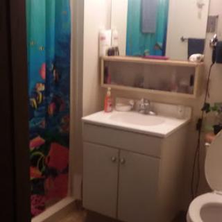 A cozy bathroom featuring a sink, toilet, and a colorful shower curtain.