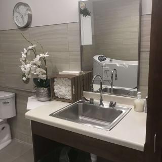 A well-organized bathroom with a sink, mirror, and floral decor.