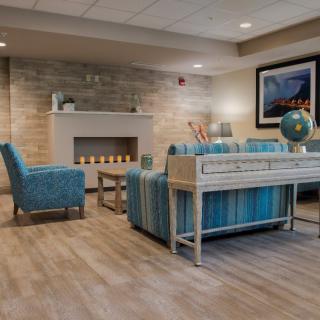 A cozy and modern living room with blue furniture and a fireplace.