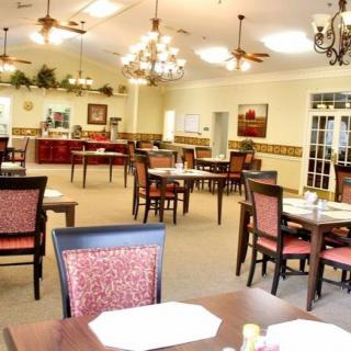 An elegant dining room setup with tables and chairs arranged neatly under chandeliers.