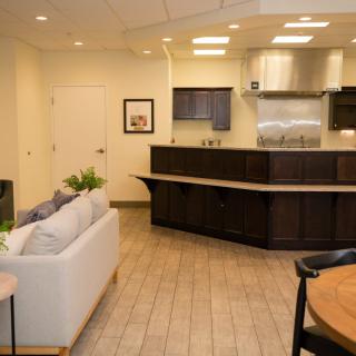 A modern open-plan kitchen and living area featuring sleek cabinetry and comfortable seating.