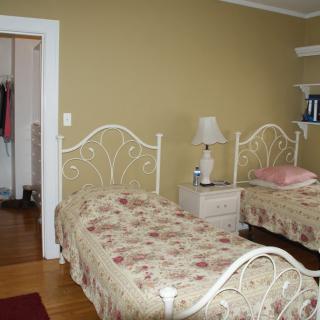 A cozy bedroom with twin beds adorned in floral bedspreads, featuring a nightstand and lamp.