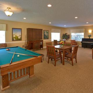A cozy game room featuring a pool table and comfortable seating area.