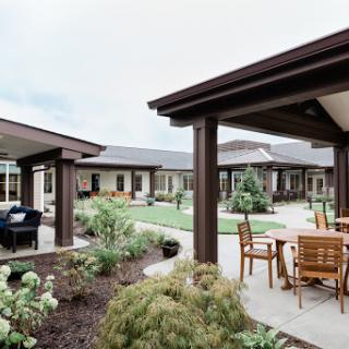 A tranquil courtyard featuring modern outdoor seating and lush landscaping.