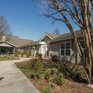 A residential house with a landscaped garden and clear weather.