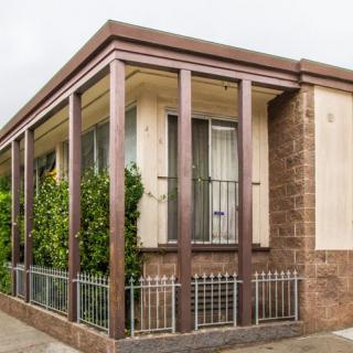 A modern house with large windows and a decorative fence.
