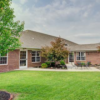A beautiful residential building surrounded by well-maintained landscaping and lush green grass.