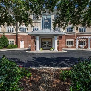 A welcoming entrance to a building framed by greenery and trees.