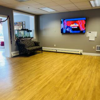 A spacious waiting area featuring a comfortable couch, a television, and an aquarium.