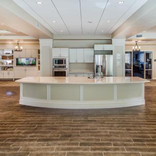 A modern kitchen with white cabinetry, a large island counter, and hardwood flooring.