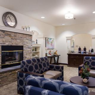A cozy and modern living room with a stone fireplace, stylish furniture, and elegant decor.