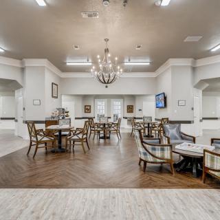 A spacious and modern dining area with elegant furnishings and a chandelier.