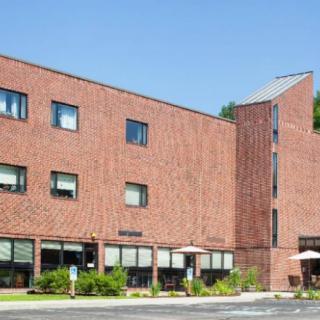 A brick building with multiple windows on a sunny day.