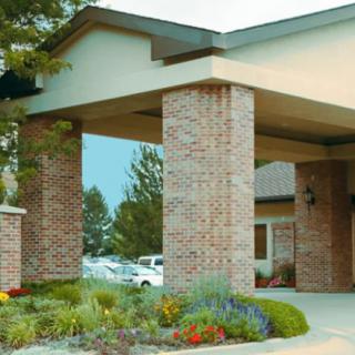 A brick building entrance with well-maintained landscaping.