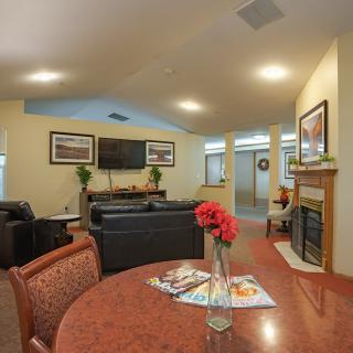 A cozy living room featuring a fireplace, comfortable seating, and a TV.