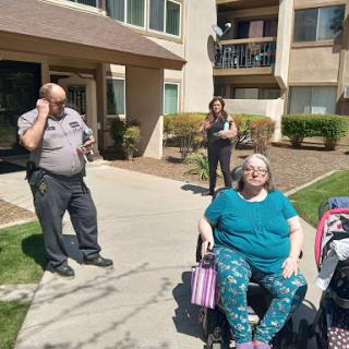 A group of individuals enjoying a sunny day outside their apartment complex.