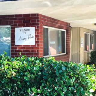 Entrance to a residential complex with a welcoming sign.